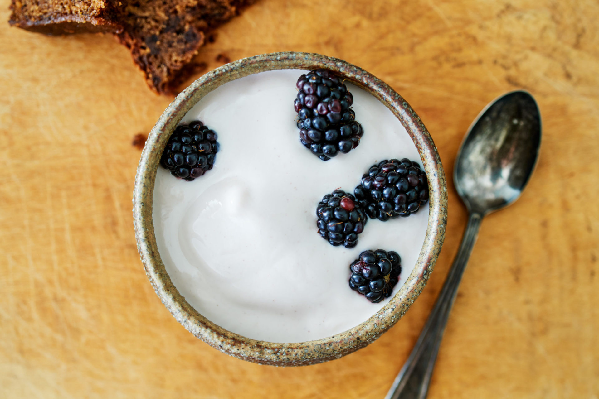 aerial view of straus organic yogurt topped with blackberries